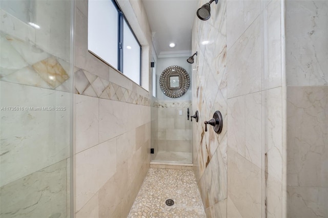 bathroom featuring a shower with door and crown molding