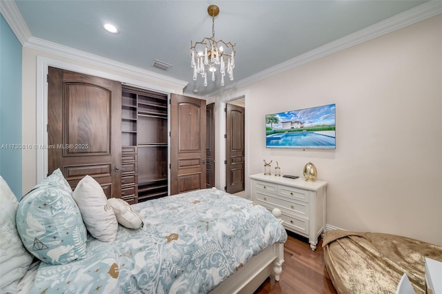 bedroom featuring an inviting chandelier, crown molding, and wood-type flooring