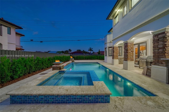 pool at dusk with an in ground hot tub, a grill, and a patio