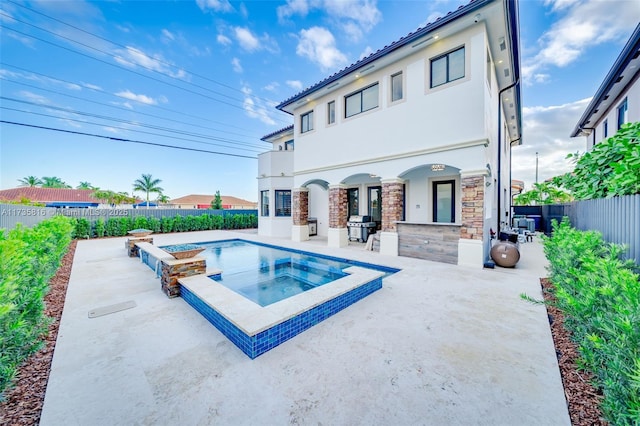 view of swimming pool with an in ground hot tub, a grill, and a patio area