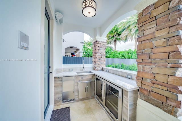 view of patio featuring sink, beverage cooler, and an outdoor kitchen