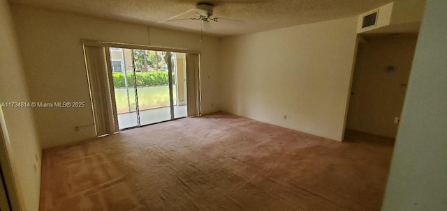 empty room featuring ceiling fan, visible vents, and a textured ceiling