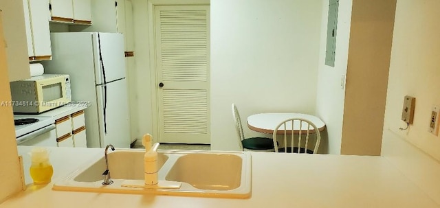 interior space with light countertops, white appliances, and white cabinetry