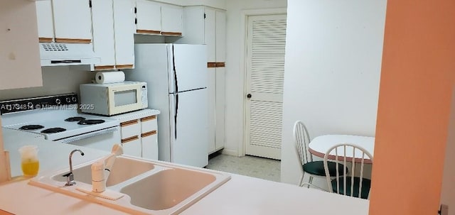 kitchen featuring light countertops, white cabinets, a sink, white appliances, and under cabinet range hood