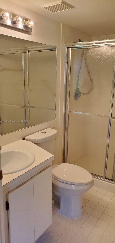 full bathroom with tile patterned flooring, toilet, vanity, visible vents, and a shower stall