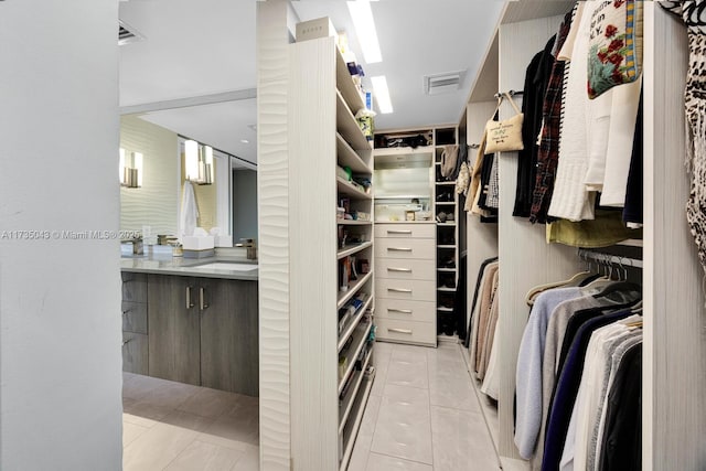 spacious closet with light tile patterned flooring and sink