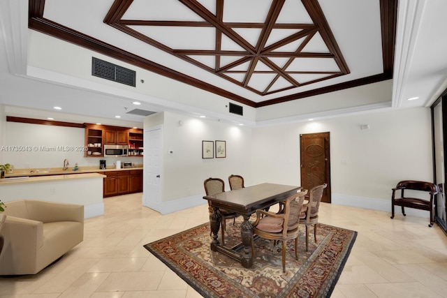 dining area with a raised ceiling, crown molding, and light tile patterned flooring