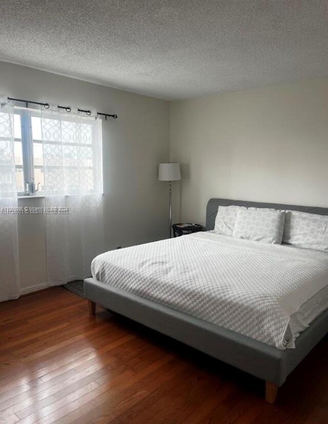 bedroom with wood-type flooring and a textured ceiling