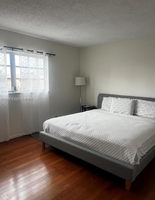 bedroom featuring hardwood / wood-style floors and a textured ceiling