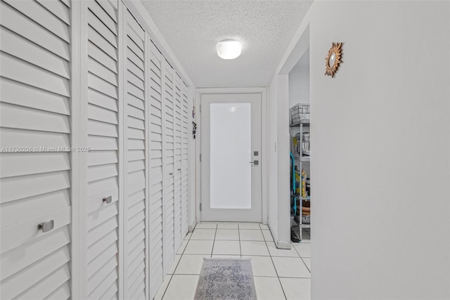 doorway featuring light tile patterned floors and a textured ceiling