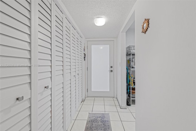 1666 W Ave Unit 207, Miami Beach, FL 33139 - hallway featuring a textured ceiling and light tile patterned floors