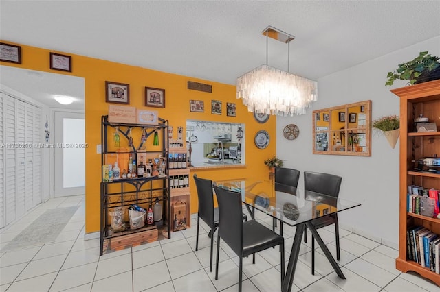 1666 W Ave Unit 207, Miami Beach, FL 33139 - dining area with a chandelier, tile patterned floors, and a textured ceiling