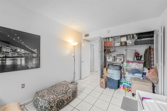 interior space featuring light tile patterned floors and a textured ceiling