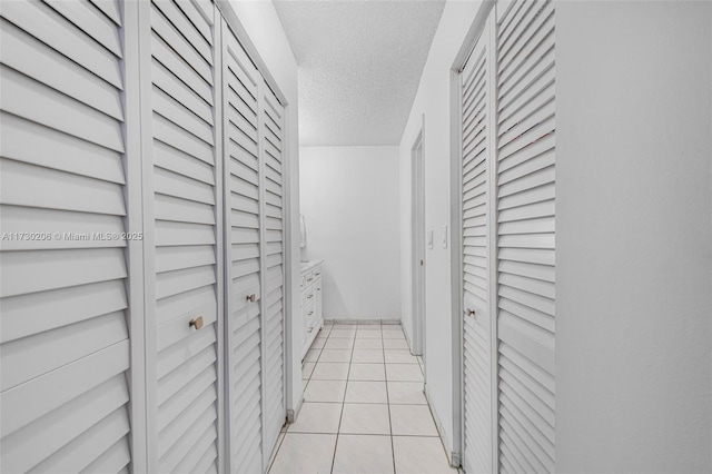 1666 W Ave Unit 207, Miami Beach, FL 33139 - corridor featuring a textured ceiling and light tile patterned flooring