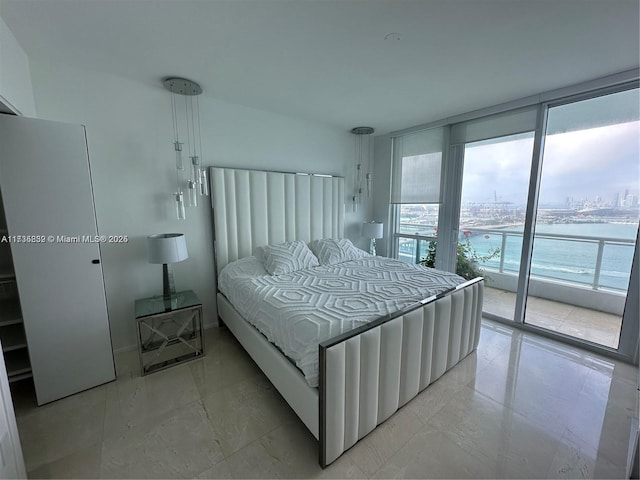 bedroom with access to outside, expansive windows, and a water view