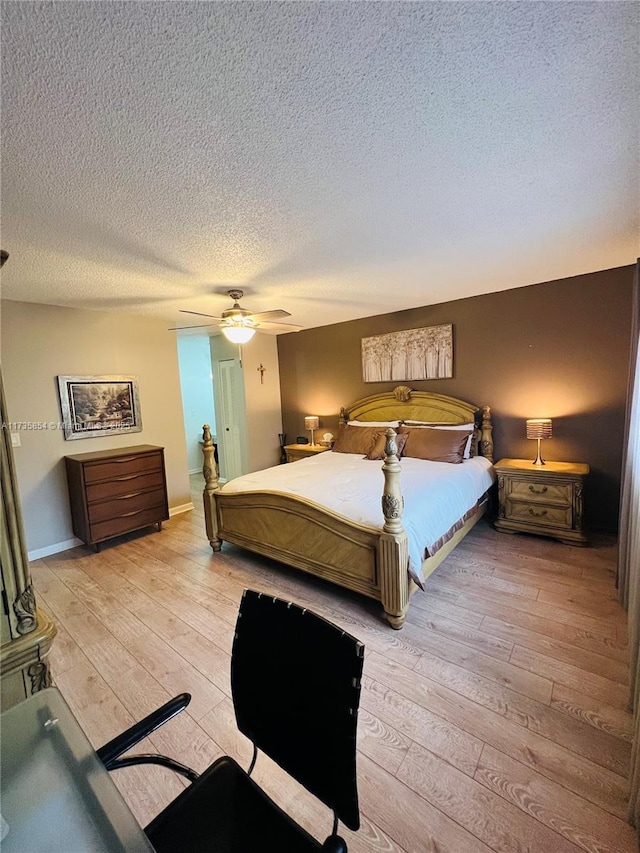 bedroom with a textured ceiling, ceiling fan, and light hardwood / wood-style flooring