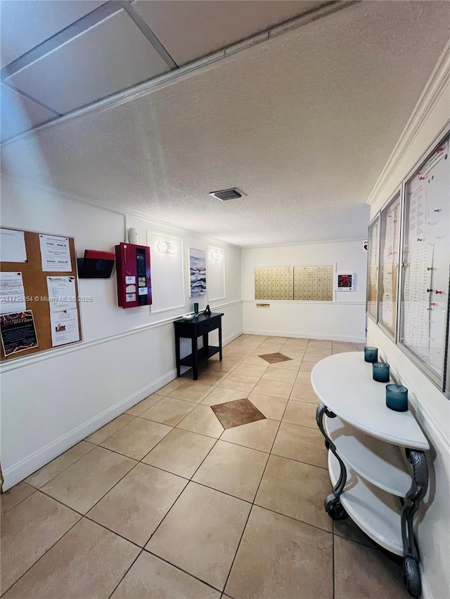 corridor with ornamental molding, a textured ceiling, and light tile patterned flooring