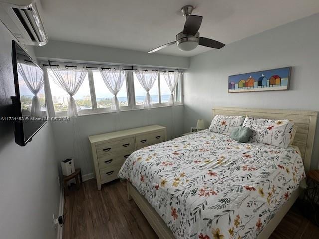 bedroom featuring ceiling fan, dark hardwood / wood-style flooring, and a wall mounted AC