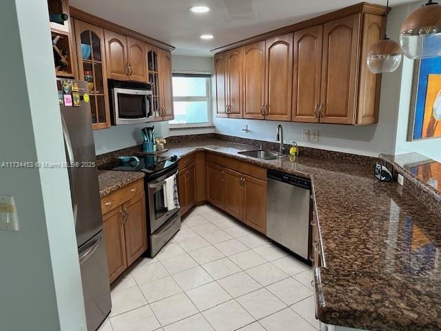 kitchen featuring light tile patterned flooring, appliances with stainless steel finishes, sink, and dark stone counters