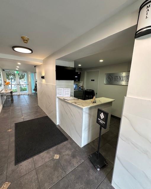 interior space featuring a kitchen breakfast bar, kitchen peninsula, and dark tile patterned floors