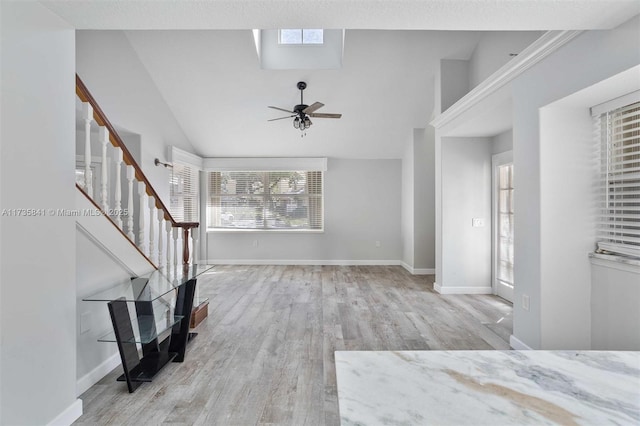 unfurnished living room featuring ceiling fan, lofted ceiling, and light hardwood / wood-style floors