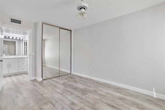 unfurnished bedroom featuring a closet and light wood-type flooring