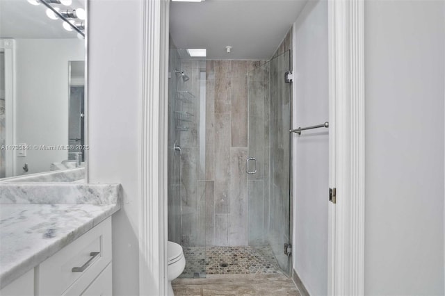 bathroom with vanity, toilet, and walk in shower