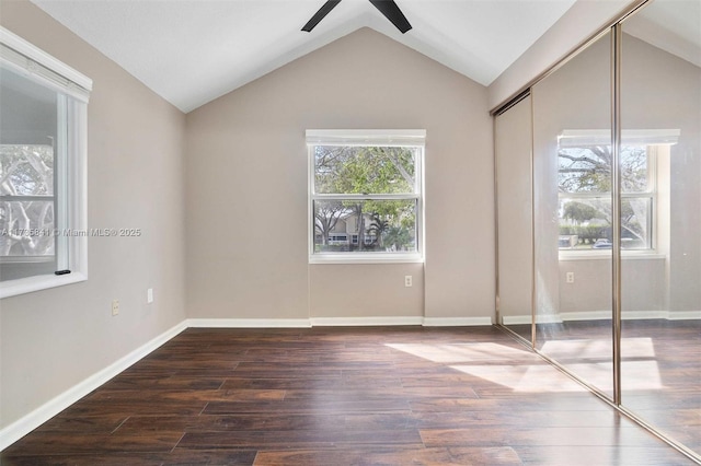 unfurnished bedroom with lofted ceiling, dark hardwood / wood-style flooring, and a closet