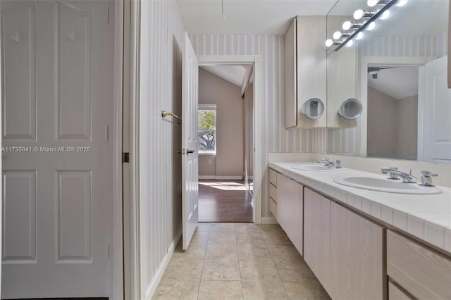 bathroom with vaulted ceiling, vanity, and tile patterned floors