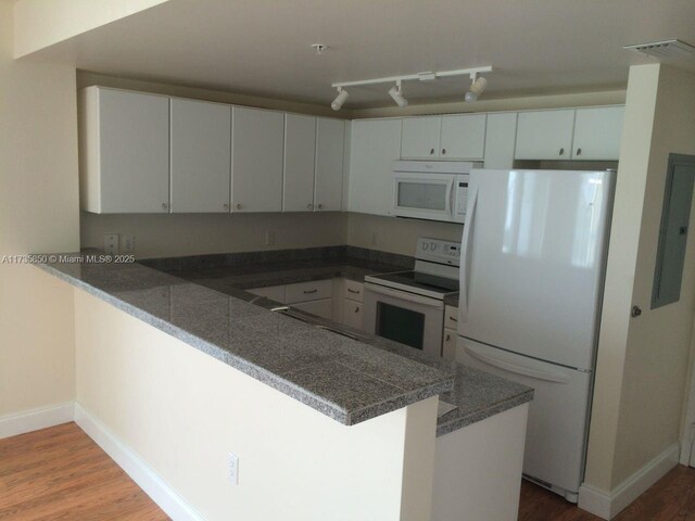 kitchen featuring hardwood / wood-style floors, white cabinets, white appliances, and kitchen peninsula