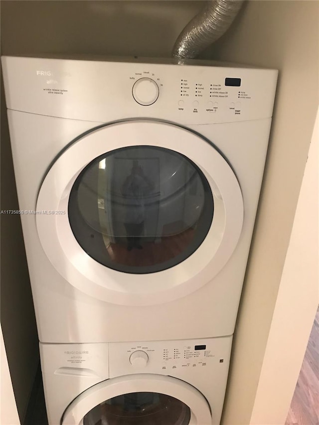 laundry room featuring stacked washer / drying machine