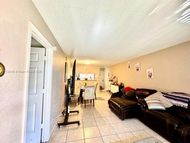 tiled living room with a textured ceiling