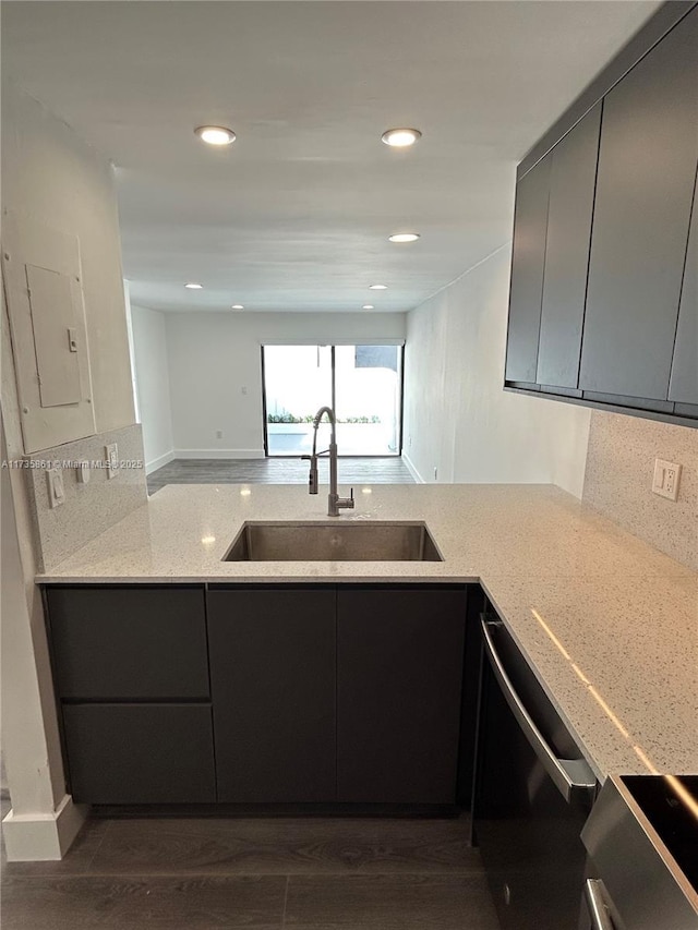 kitchen featuring sink, dishwasher, stove, electric panel, and light stone countertops