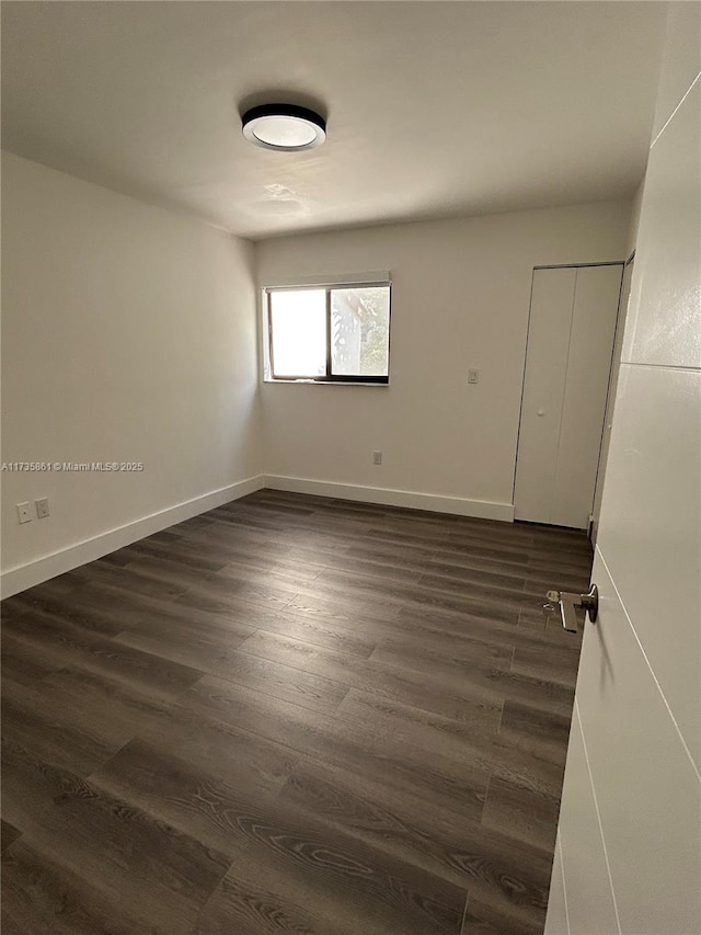 unfurnished room featuring dark wood-type flooring