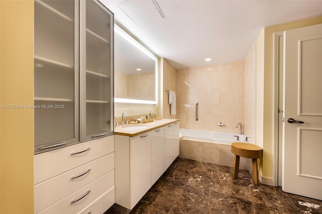 bathroom featuring vanity and tiled bath