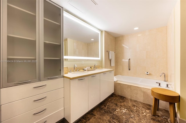 bathroom featuring vanity and tiled tub