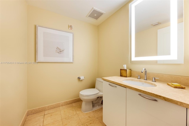 bathroom with vanity, tile patterned flooring, and toilet