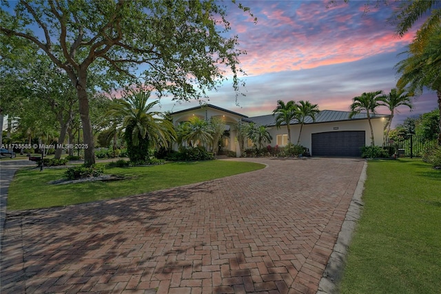 view of front facade featuring a garage and a yard