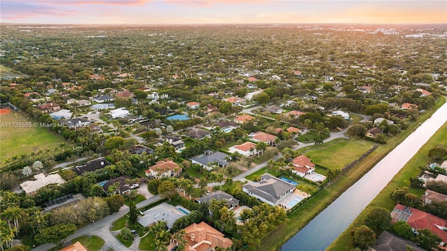 aerial view at dusk featuring a water view