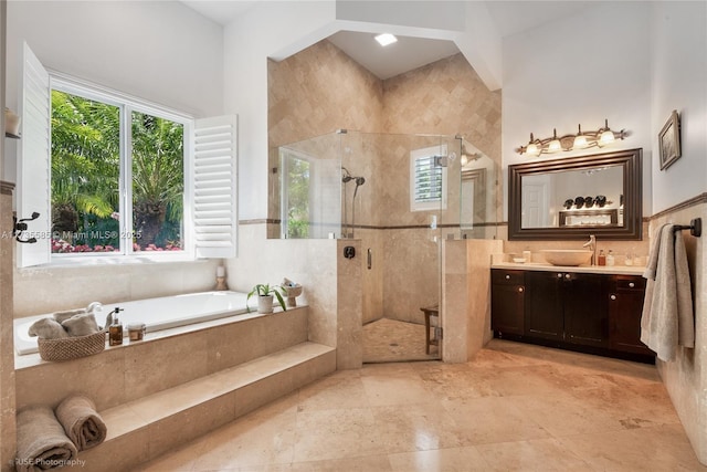 bathroom with plus walk in shower, a healthy amount of sunlight, and vanity