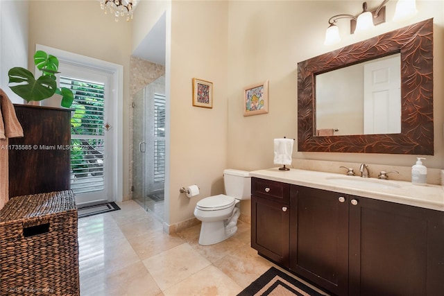 bathroom featuring vanity, toilet, a shower with door, tile patterned floors, and an inviting chandelier