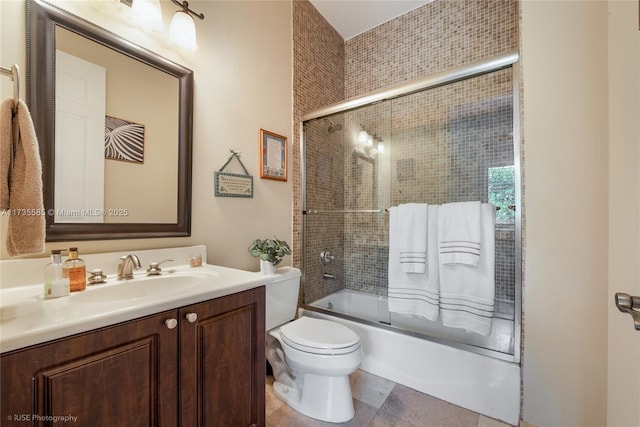 full bathroom with vanity, toilet, and combined bath / shower with glass door