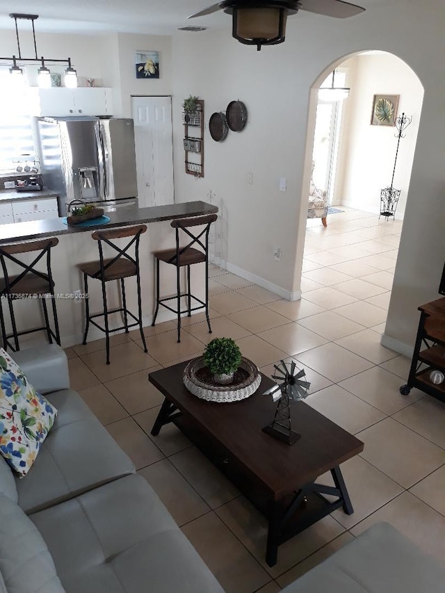 tiled living room with ceiling fan