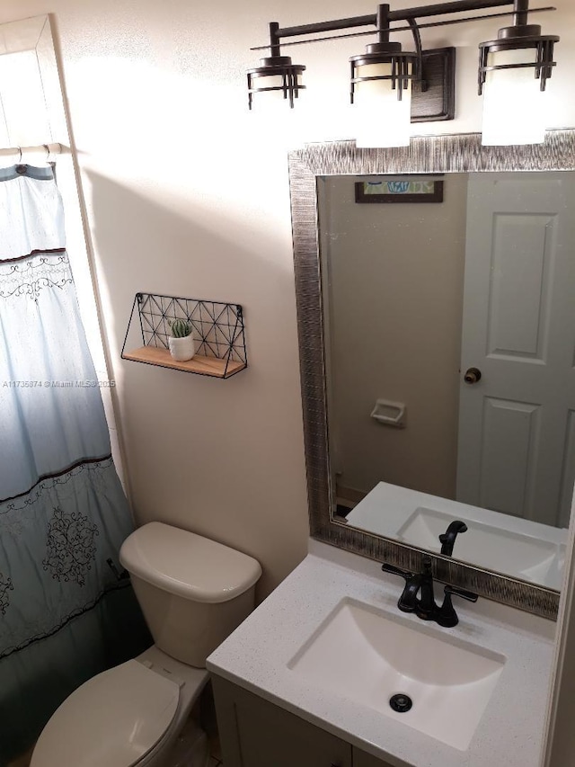 bathroom featuring vanity, toilet, and curtained shower