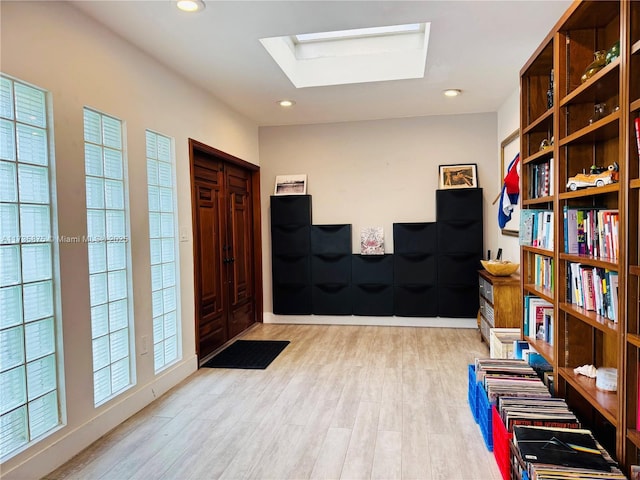 interior space featuring a skylight and light wood-type flooring