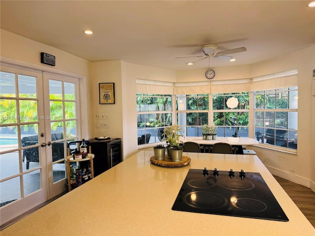 kitchen featuring black electric stovetop, hardwood / wood-style floors, french doors, and ceiling fan