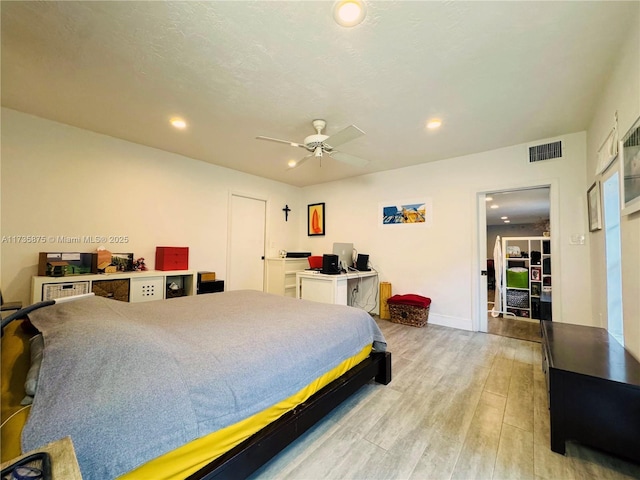 bedroom featuring a textured ceiling, ceiling fan, and light wood-type flooring