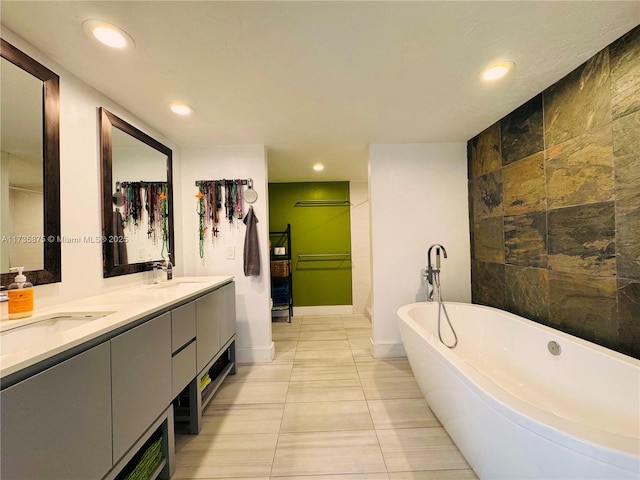 bathroom featuring vanity, a washtub, and tile patterned floors