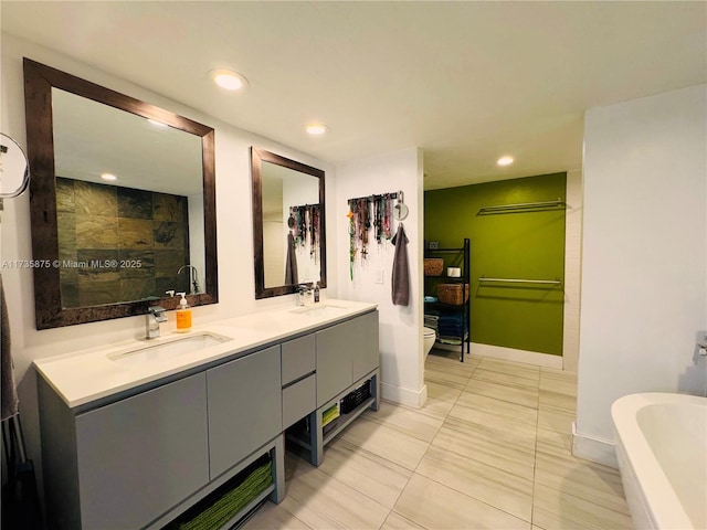 bathroom featuring vanity, a washtub, and toilet