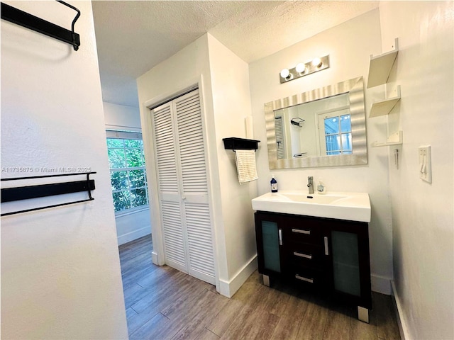 bathroom with wood-type flooring, a textured ceiling, and vanity